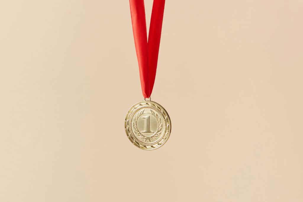 Gold first-place medal with red ribbon