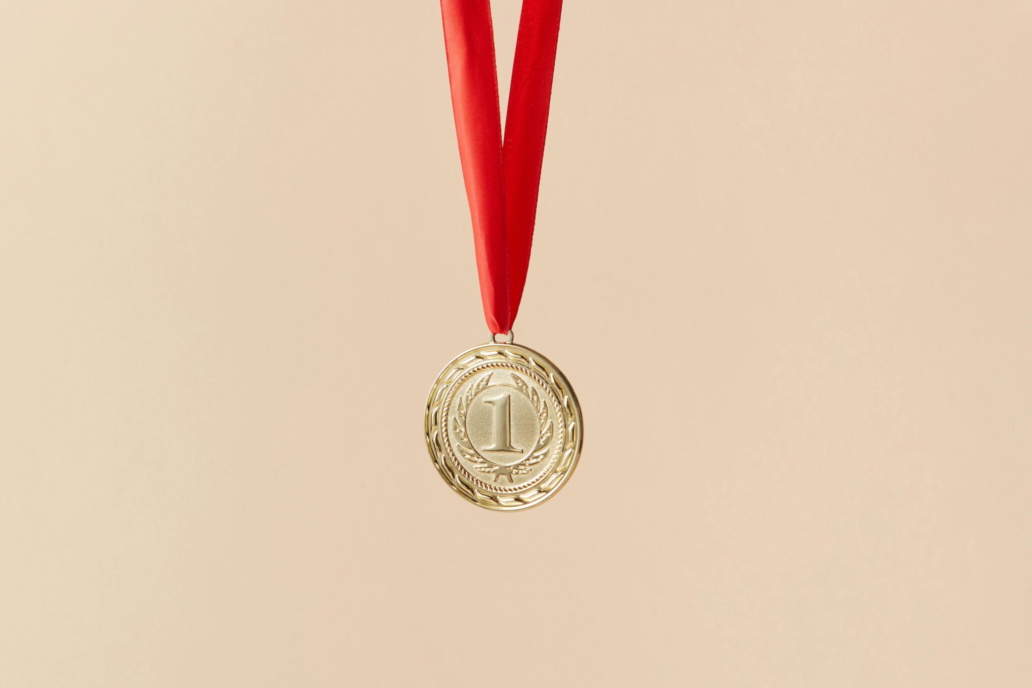 Gold first-place medal with red ribbon