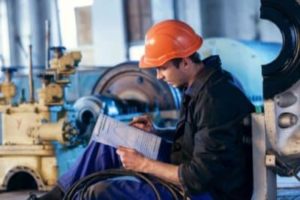 Man in hardhat reading from a binder