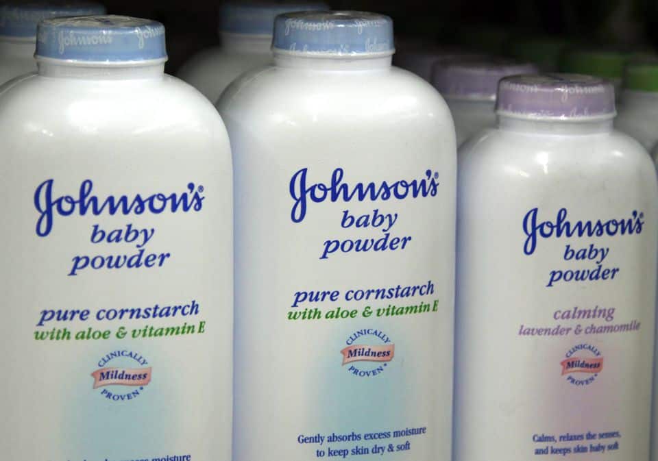 Johnson's Baby Powder bottles lined up on store shelf.